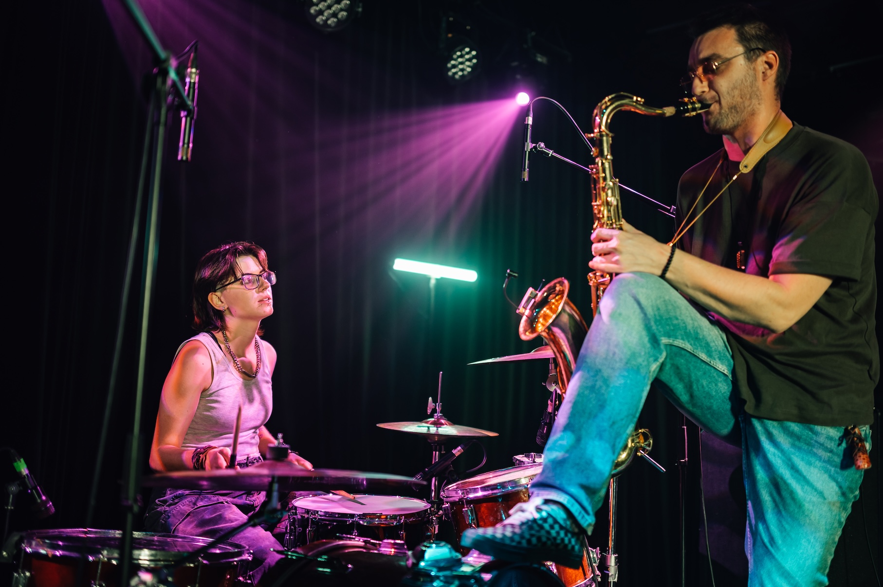 Musicians playing saxophone and drums during live performance